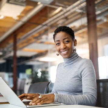 A woman works from a laptop at her office