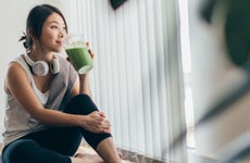 Young Asian Woman Drinking Green Smoothie After Yoga