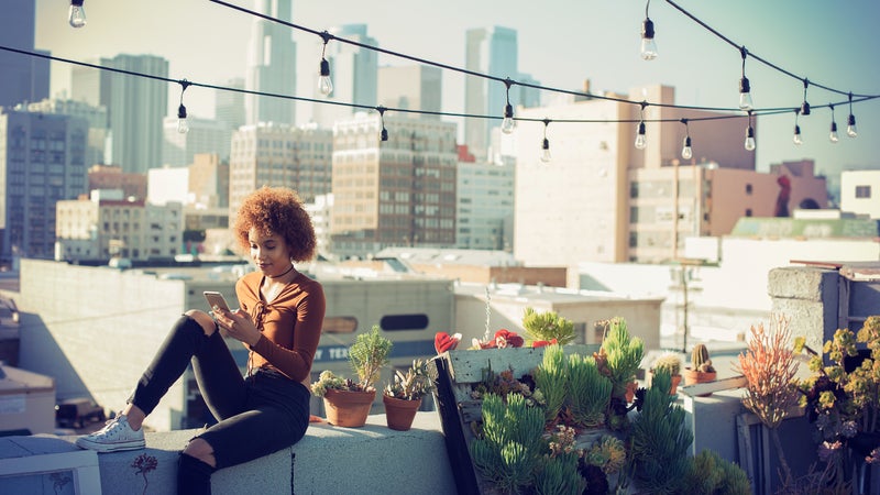 Woman checking smartphone on rooftop
