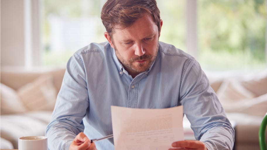 Man looks with concern at paperwork