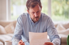 Man looks with concern at paperwork