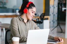 woman works on laptop with headphones on