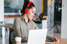 woman works on laptop with headphones on