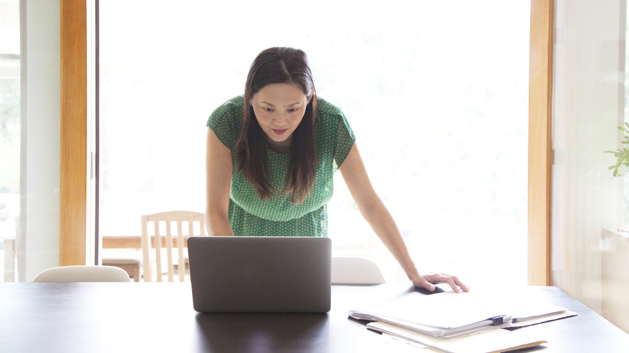 Korean woman using laptop in dining room