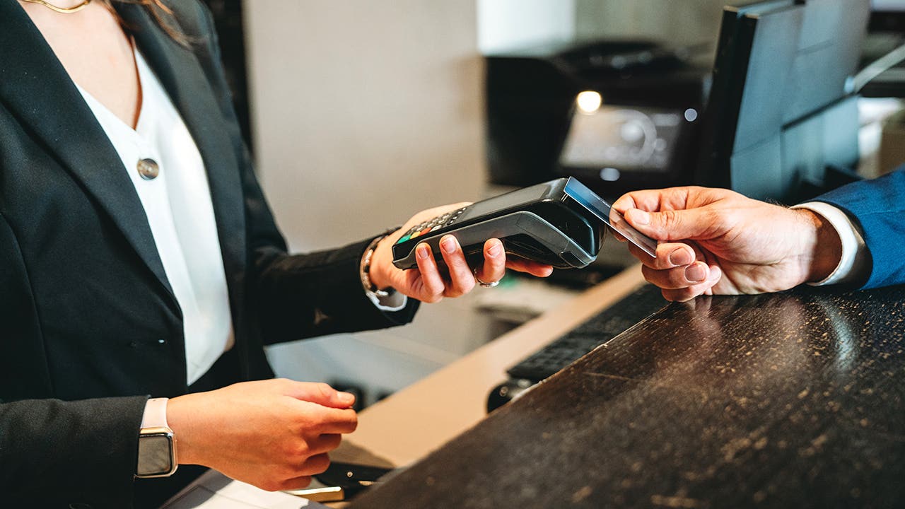 A businessman is paying with credit card at the hotel reception