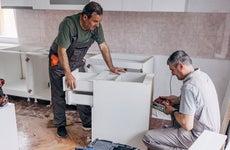 two men working on a cabinet during kitchen renovation