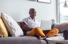 Senior woman using laptop on couch at home