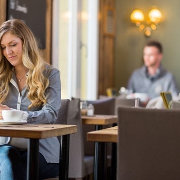 Woman works on a tablet at a cafe