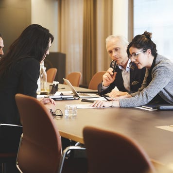 Male and female lawyers discussing over document at conference table in meeting