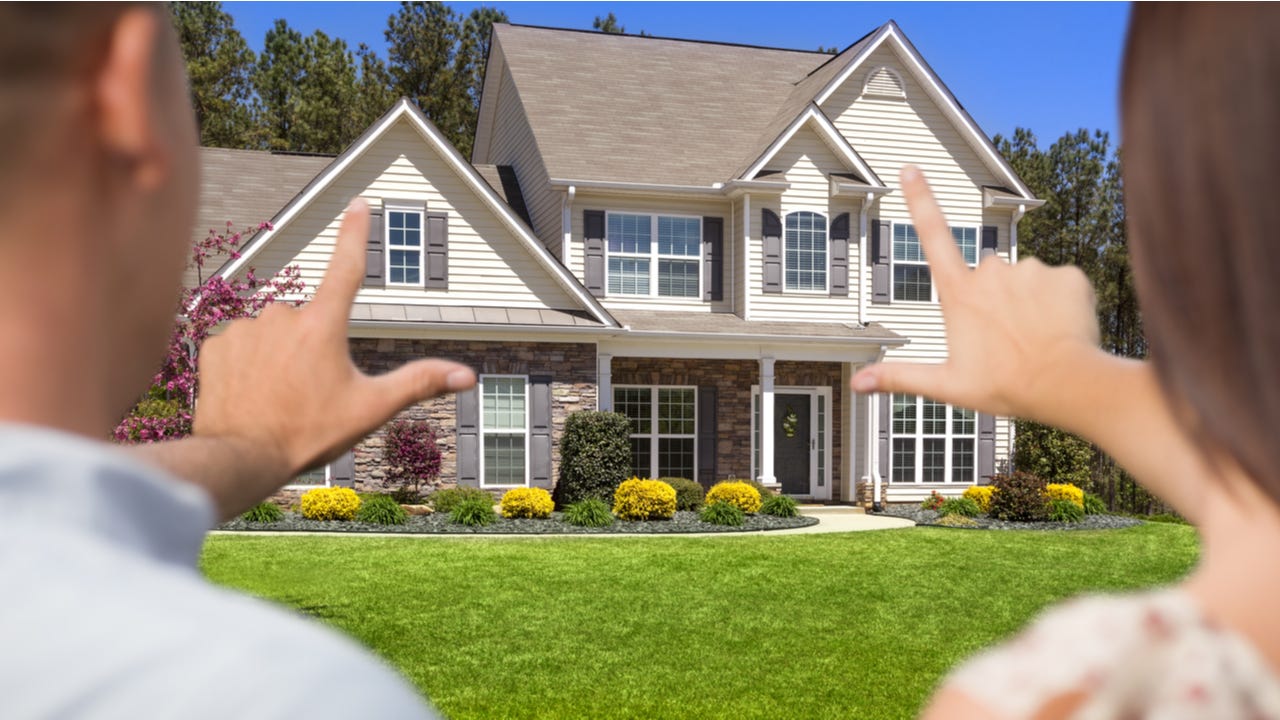 Couple standing in front of home evaluating it