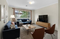 A living room digitally-staged with brown and blue accents