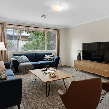 A living room digitally-staged with brown and blue accents