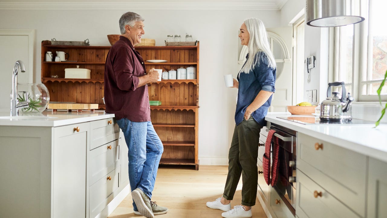 Couple talking while having coffee in kitchen