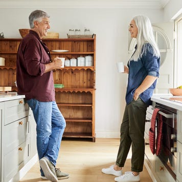 Couple talking while having coffee in kitchen