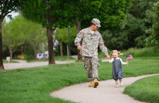 Service member walks in the park with young daughter