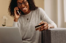 woman on phone holding credit card