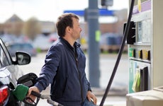 Middle-aged man pumps gas