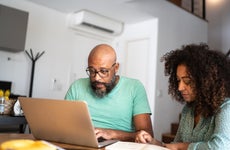 Couple using laptop to pay bills or shopping at home