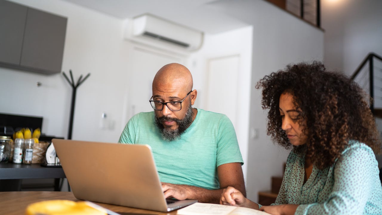 Couple using laptop to pay bills or shopping at home