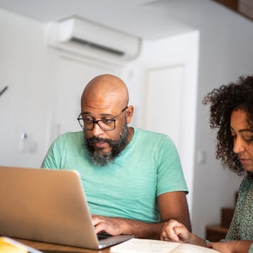 Couple using laptop to pay bills or shopping at home