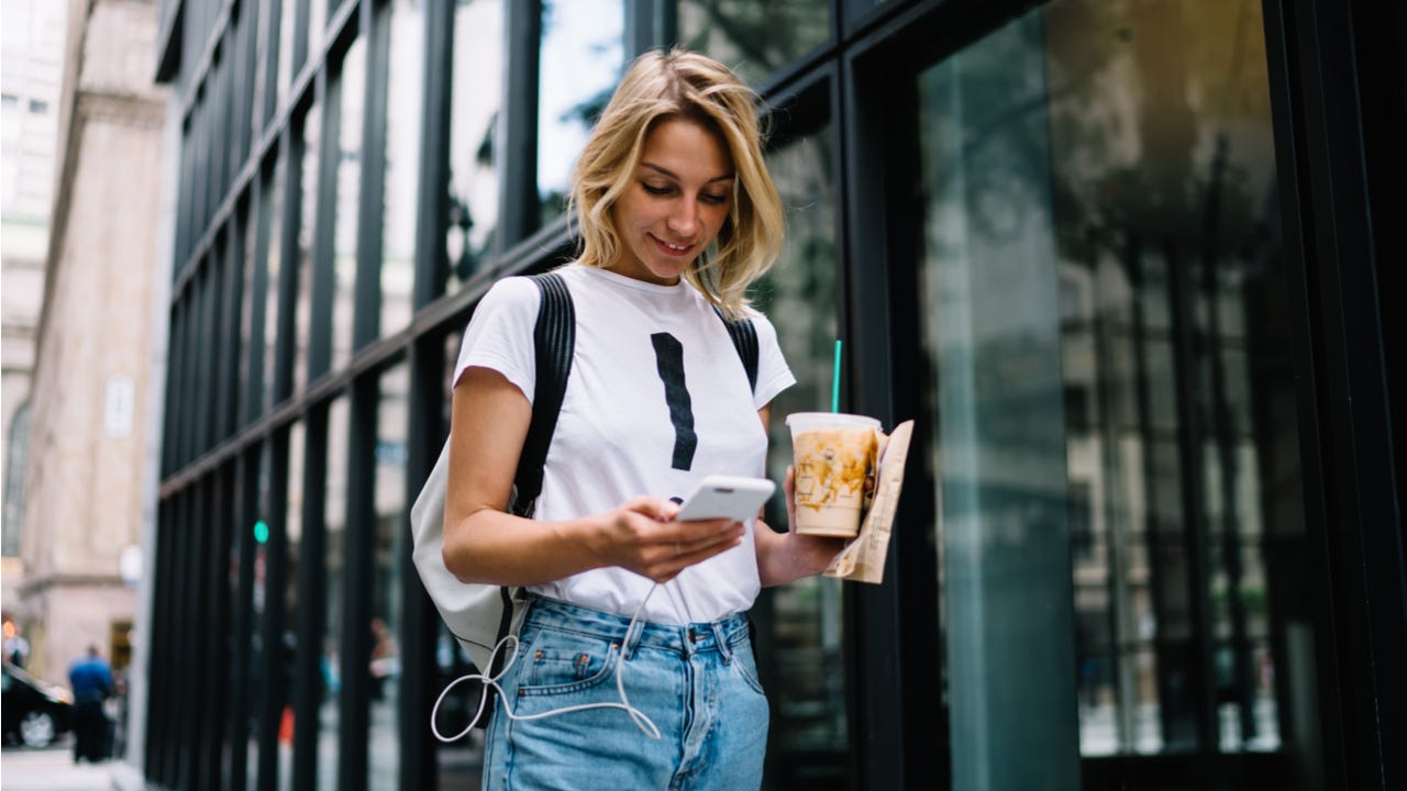 Woman walks down the street on her phone