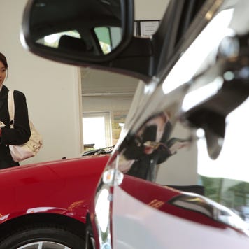 chinese female executive in car showroom