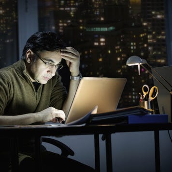 Mixed race businessman working late in office