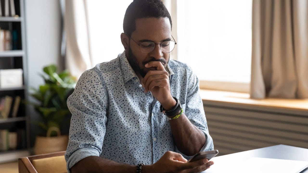 A man looks over his phone pensively