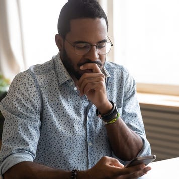 A man looks over his phone pensively