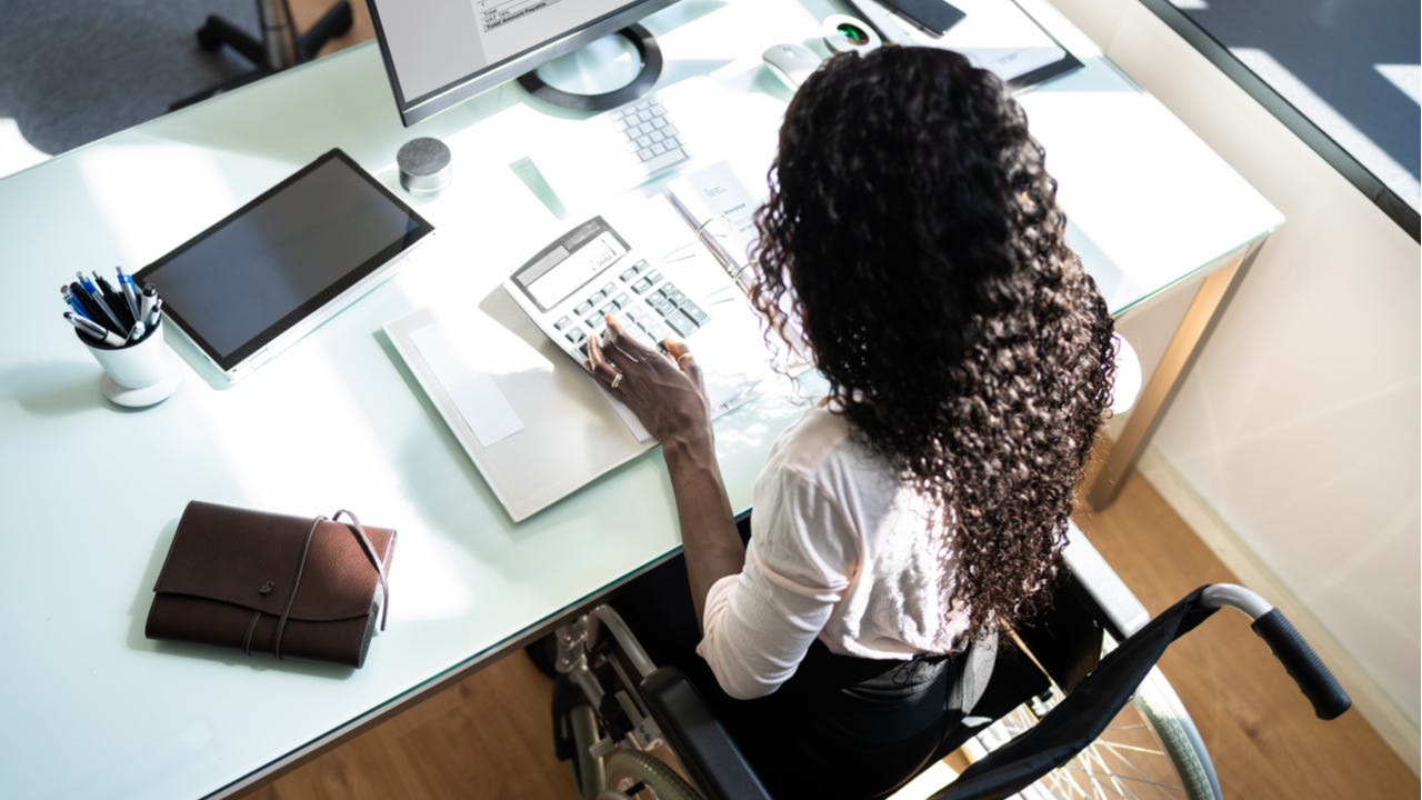 Woman in a wheelchair using calculator