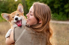 A woman holds her smiling dog