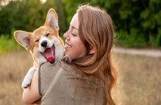 A woman holds her smiling dog