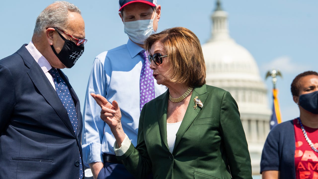 Speaker of the House Nancy Pelosi speaks with Chuck Schumer in front of the U.S. Capitol