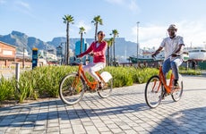 An older couple bikes through a public plaza
