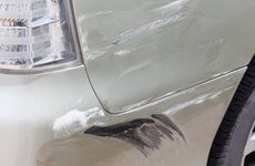 Close up of scratch in paint on white car