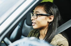 Young woman preparing to drive car