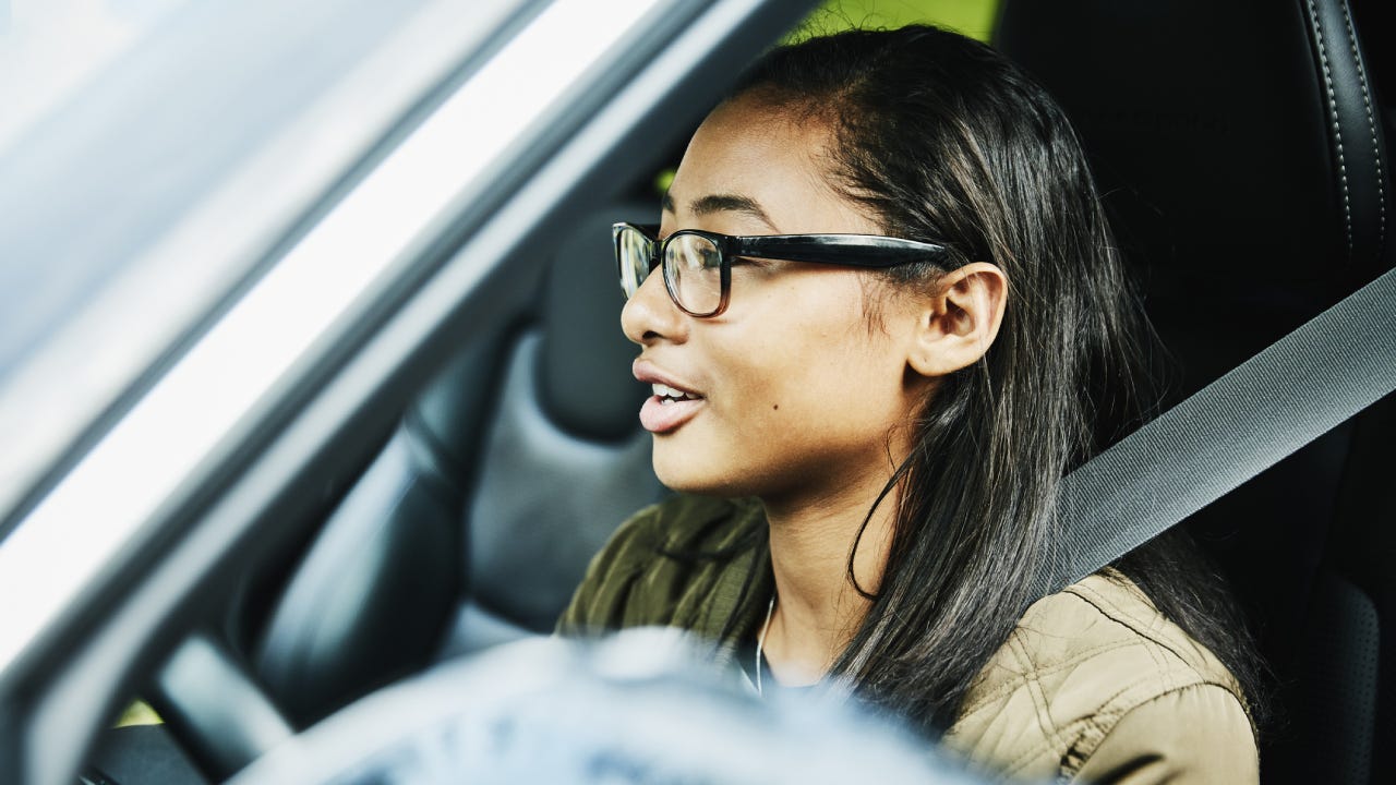 Young woman preparing to drive car