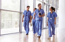Group of nurses walk down a hallway