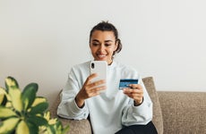 Young woman with credit card on smartphone