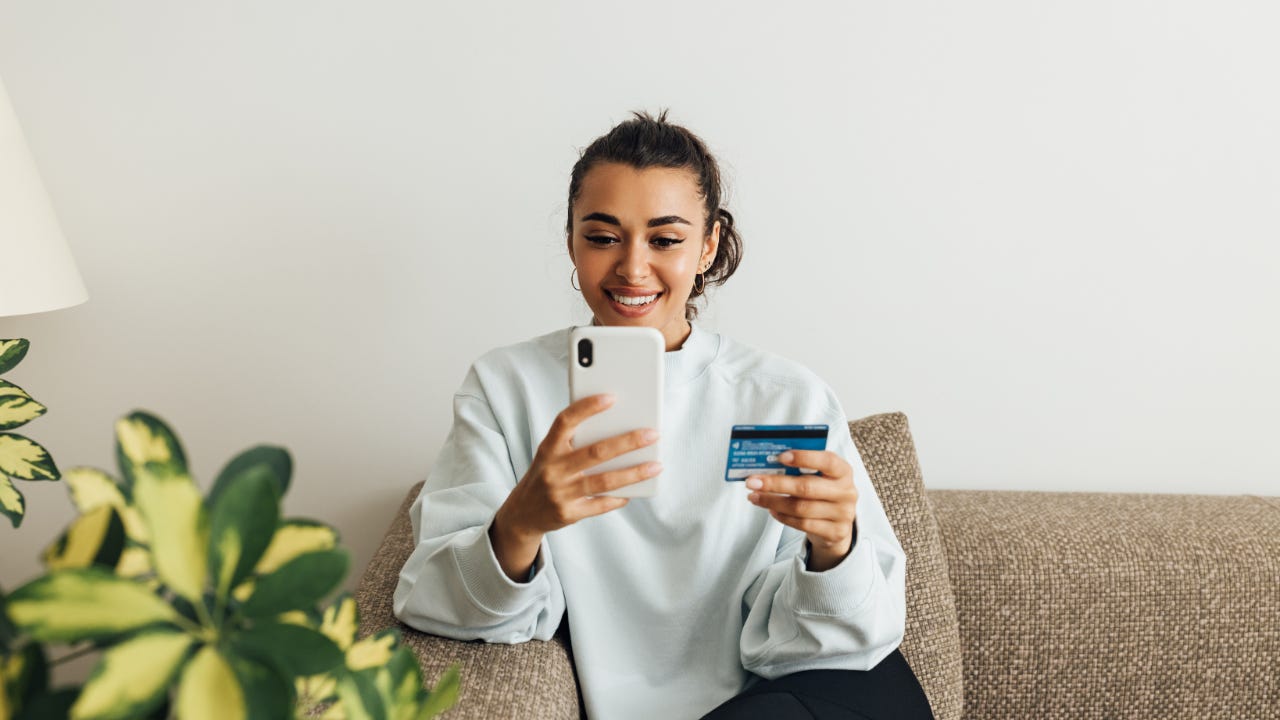 Young woman with credit card on smartphone