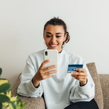 Young woman with credit card on smartphone