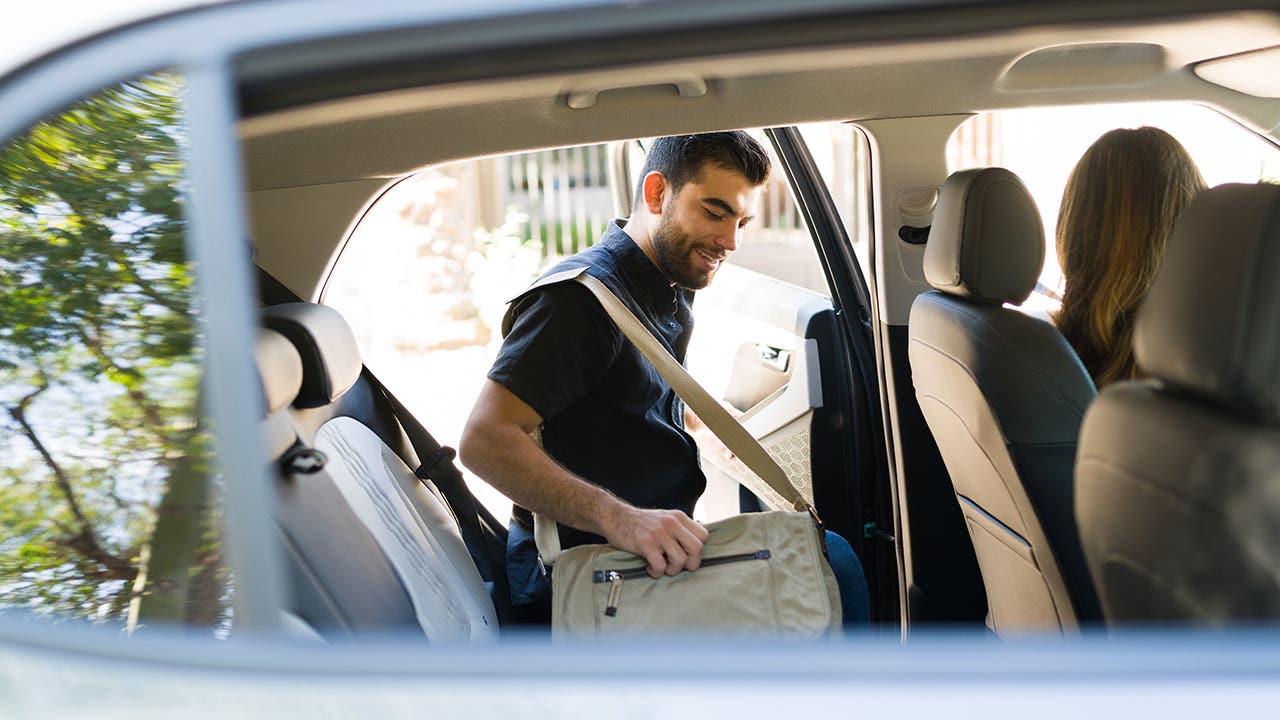 male passenger getting into the backseat of a rideshare car