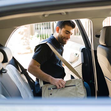 male passenger getting into the backseat of a rideshare car
