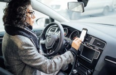 Woman uses navigation on her mobile phone in the car