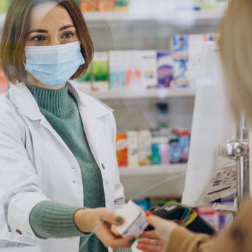 Pharmacist hands medication to customer