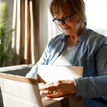 Excited senior woman unpacking online order