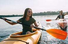 Young couple smiling and kayaking on a lake