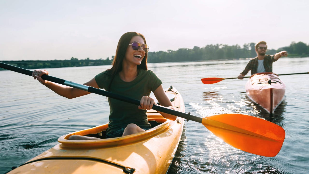 Young couple smiling and kayaking on a lake