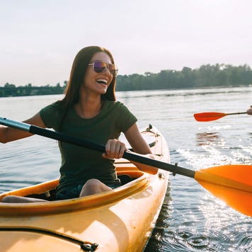 Young couple smiling and kayaking on a lake