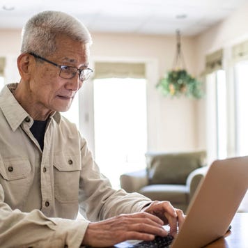 Senior man using his laptop in his kitchen